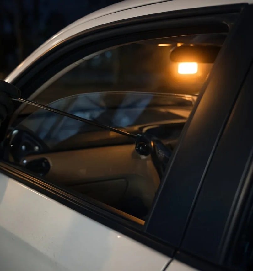 A car door eased open at the window frame, interior light on